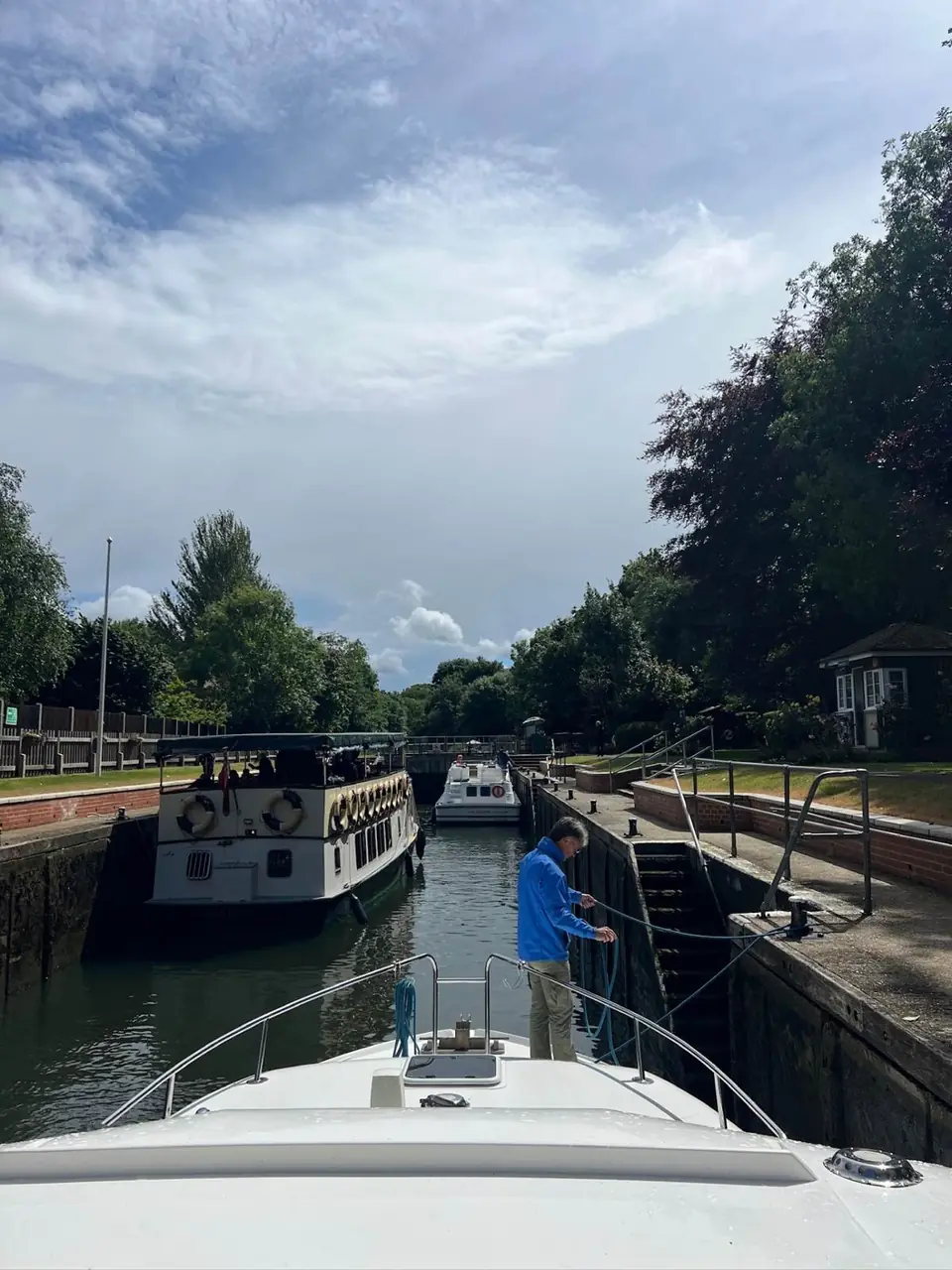 A boat owner stepping aboard their moored narrowboat on a quiet canal